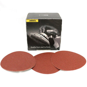 Box of Mirka sanding discs with photo of someone sanding. Three sanding discs shown in front of the box.